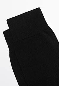 Black cotton socks with a ribbed texture, featuring a thick cuff at the top, designed for comfort and durability.