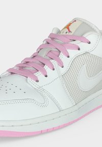 Λευκό και ανοιχτό γκρι αθλητικό παπούτσι Nike Air με ροζ κορδόνια και ροζ άκρη σόλας, με οπές και πλέγμα στην πλαϊνή επιφάνεια.