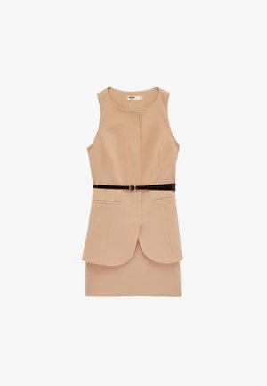 Robe beige sans manches avec encolure ronde, détail de couture avant, poches latérales et ceinture noire fine avec boucle dorée à la taille.