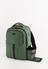 Mochila verde de nailon con un diseño estructurado, que cuenta con un bolsillo frontal con cremallera, un bolsillo lateral y correas de hombro acolchadas. Detalle de hardware ajustable en los laterales.