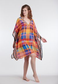 Värviline kaftan, millel on lapitöödisain kollases, punases, sinises ja oranžis, v-kaelusega ning detailne ääris hemmi ja dekoltee ümber.