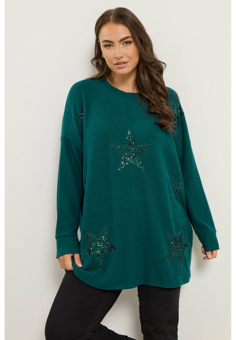 Pull overdimensionné teal avec des manches longues, orné de motifs d'étoiles noires scintillantes sur le devant. Tissu doux avec une coupe décontractée et un ourlet arrondi.