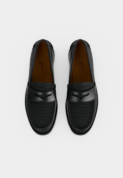 Porą juodų odinių lakuotų batų su austu paviršiumi viršuje ir lygiu dirželiu priekyje, pateiktų ant balto fono.