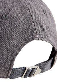 Grå stof baseball cap med en struktureret overflade, en rund krone og en justerbar rem med en sølvmetal spænde.