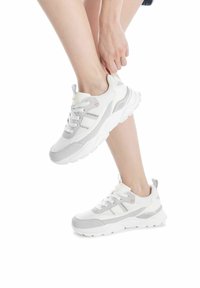 Sneaker bianche con accenti grigi, caratterizzate da una parte superiore testurizzata, chiusura con lacci e una suola ammortizzata. Progettate con un'etichetta per indossarle facilmente.