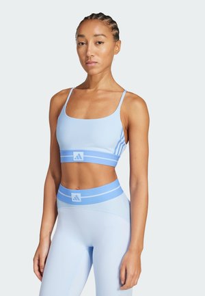 Sujeción deportiva de color azul claro con finas tirantes, combinado con leggings de cintura alta a juego que presentan rayas horizontales contrastantes y un logotipo.