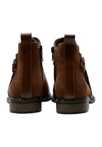 Stivali ankle in suede marrone con pannello in pelle liscia, punta arrotondata, cerniera laterale e cuciture tonali. Dettaglio del tacco e logo ben visibili sul lato.