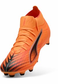 Scarpa da calcio arancione brillante con parte superiore texturizzata, accenti neri e design a vestibilità aderente. Presenta chiusura con lacci e tacchetti conici.
