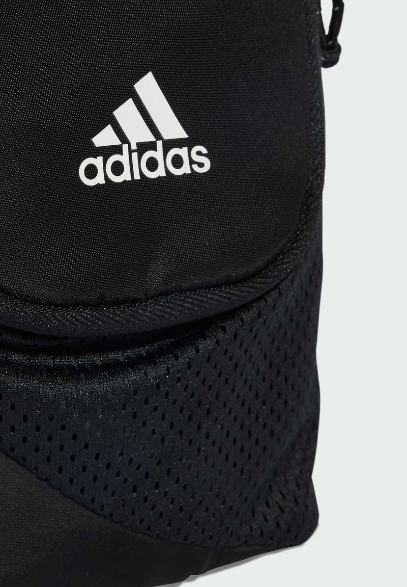 Zwarte Adidas sporttas met wit logo, met een gestructureerd mesh onderste gedeelte en zichtbare stiksels op de stof.