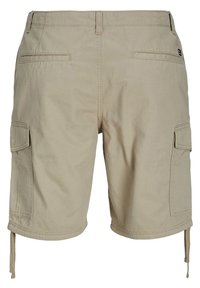 Beige cargo shorts valmistettu puuvillasta, jossa on kaksi sivutaskua, kaksi takataskua ja säädettävät nyörit helman kohdalla. Sujuva pinta.