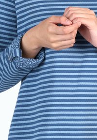 Blaues Langarmoberteil mit horizontalen Streifen in verschiedenen Farbtönen. Die Ärmel sind mit einem floralen Muster versehen. Strukturierter Stoff mit lockerer Passform.