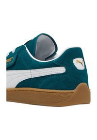 Tealfarbene Wildleder-Sneaker mit weißen Lederakzenten, flacher Sohle aus Gummi und goldfarbener, eingeprägter Logo auf der Außenseite. Abgerundetes Fersen-Design.