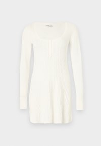 Λευκό πλεκτό φόρεμα με μακριά μανίκια, στρογγυλή λαιμόκοψη και σχέδιο πλεξούδας. Διαθέτει κουμπιά στο εμπρόσθιο μέρος και ριμπ μανσέτες.