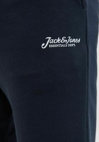 Navyblauwe katoenen sweatshirt met een gestructureerd oppervlak, voorzien van witte borduursel "Jack & Jones Essentials Dept." op de voorkant.