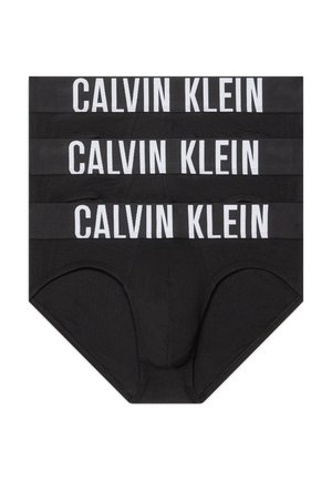 Trois slips noirs pour hommes empilés, chacun avec une large ceinture portant "CALVIN KLEIN" en grandes lettres blanches.