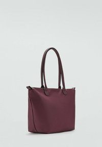 Burgundska platnena torba s dva smeđa ručka, pravokutnog oblika, prostranog dizajna i zatvaranjem na patentni zatvarač s jedne strane. Glatka tekstura.