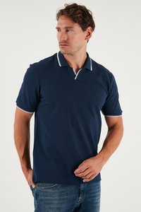Mornarska polo majica od mekog materijala, s ovratnikom s bijelim obrubom i kratkim rukavima, u kombinaciji s plavim trapericama.