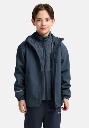Veste imperméable bleu marine avec une capuche amovible, des poignets élastiques, deux poches latérales et une fermeture éclair à l'avant sur une couche intérieure plus légère.