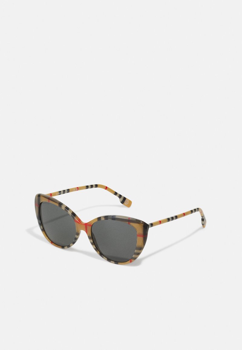 Lunettes de soleil en forme d'yeux de chat avec un motif écossais multicolore dans des teintes de brun, orange et noir ; verres foncés ; branches fines avec des rayures.