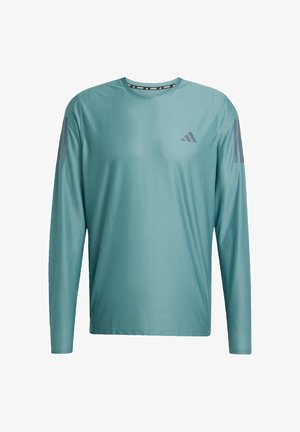 Langärmliges Sporthemd in Teal mit rundem Ausschnitt. Verfügt über dezente graue Akzente an den Schultern und ein Logo auf der Brust. Glatte Stoffstruktur.