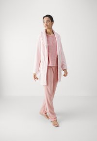Light pink fleece loungewear set featuring a hooded robe, long-sleeve top, and pants. Soft texture and relaxed fit with pockets.
