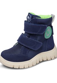 Granatowe, wodoodporne buty z rzepami, teksturowana tkanina i zielony akcent w logo. Chmurowa, biała podeszwa zapewniająca przyczepność.