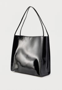 Czarna torba na ramię z lakierowanej skóry o gładkiej fakturze, prostokątnym kształcie i długich uchwytach. Minimalistyczny design bez widocznych elementów metalowych.