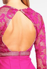 Fuchsijové šaty s dlouhými, průhlednými krajkovými rukávy s květinovými vzory, s otevřeným zadním dílem a strukturovaným pasem s dekorativním lemem.