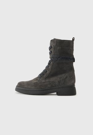 Bottines en daim gris avec une finition texturée, des lacets bleus et une semelle en caoutchouc noir robuste. Comprend une boucle à l'arrière pour un enfilage plus facile.