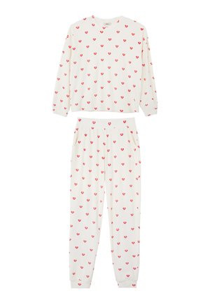 Ensemble de pyjama blanc composé d'un haut à manches longues et d'un pantalon, tous deux décorés d'un motif de cœurs rouges. Tissu doux avec taille élastique et poches.