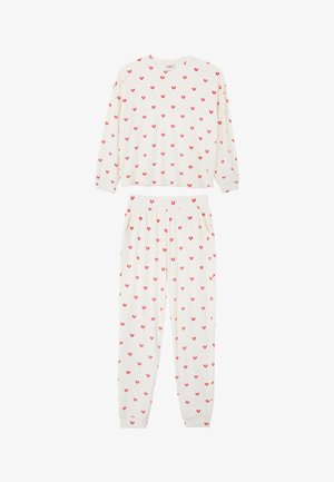 Weißes Pyjamaset bestehend aus einem langärmligen Oberteil und einer Hose, beide mit einem roten Herzmuster verziert. Weicher Stoff mit elastischem Bund und Taschen.