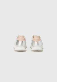 Silberne und weiße Sneakers mit glatter Textur, kontrastierenden pinken Fersenakzenten und einem einzigartigen Design mit horizontalen Nähten.