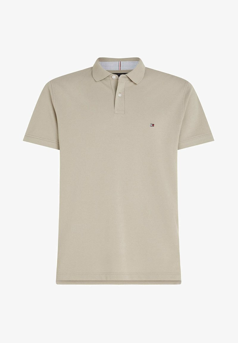 Polo shirt beige à manches courtes avec deux boutons et petit logo en forme de drapeau rectangulaire sur le côté gauche de la poitrine.