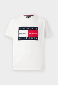 T-shirt en coton blanc avec un graphique rectangulaire bleu marine portant les inscriptions "TOMMY HILFIGER", "USA" et "SAILGP TEAM" en accents rouges et blancs.