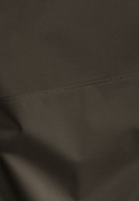 Dunkelbrauner Stoff mit glatter Textur und einer sichtbaren Naht. Das Material ist leicht glänzend und eng gewebt.