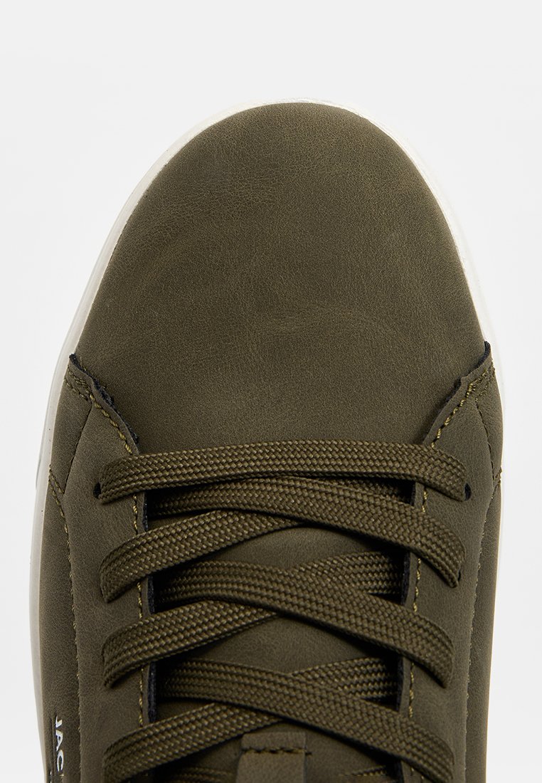 Baskets en suédine verte avec un bout rond, des lacets en textile et une semelle en caoutchouc blanc. Présente des accents de couture le long des côtés.