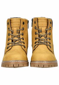 Bottines en cuir tan avec des lacets noirs, côtés texturés et semelles en caoutchouc. Présente un petit logo et un détail de couture contrasté.