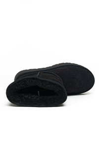 Botines de ante negro con un suave forro interior y suelas de goma texturizadas. Incluyen una cremallera lateral para facilitar su puesta.