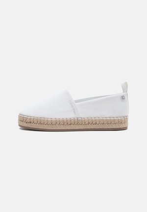 White slip-on espadrille with woven jute sole, small fabric loop at heel, and subtle brand logo on fabric upper.