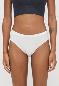 Białe bawełniane majtki bikini o gładkiej fakturze, z szerokim pasem i minimalistycznym designem. Brak widocznych wzorów lub akcentów.