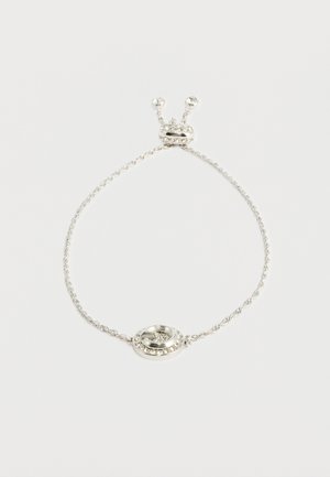 Srebrna zapestnica s zasukanim verižnim dizajnom, ki vsebuje okroglo sredino okrašeno z majhnimi prozornimi kamenčki in dekorativnim zaponko.