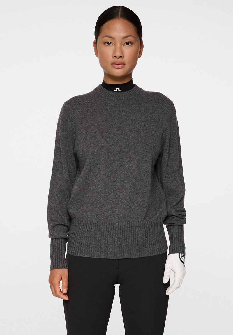 Mörkgrå stickad tröja med ribbade detaljer vid halsringning och ärmslut, med en subtil logotyp på bröstet och en passform som har ribbad nederkant.