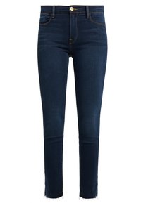 Jeans skinny de mezclilla de color azul oscuro con cintura alta, cierre de botón y dobladillos deshilachados. Cuenta con cinco bolsillos y costuras en contraste.