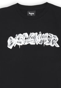 T-shirt nera in cotone con una stampa audace e bianca in stile graffiti della parola "DISCLAIMER" sul petto, con una finitura testurizzata.