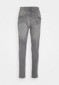 Gray denim jeans with a fitted design, two back pockets, and a smooth texture. Mid-rise waist and tapered legs.