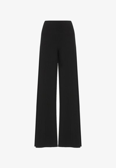 Pantalon noir à jambes larges avec une taille haute, confectionné en tissu extensible. Il présente une texture lisse et une silhouette fluide et longue.