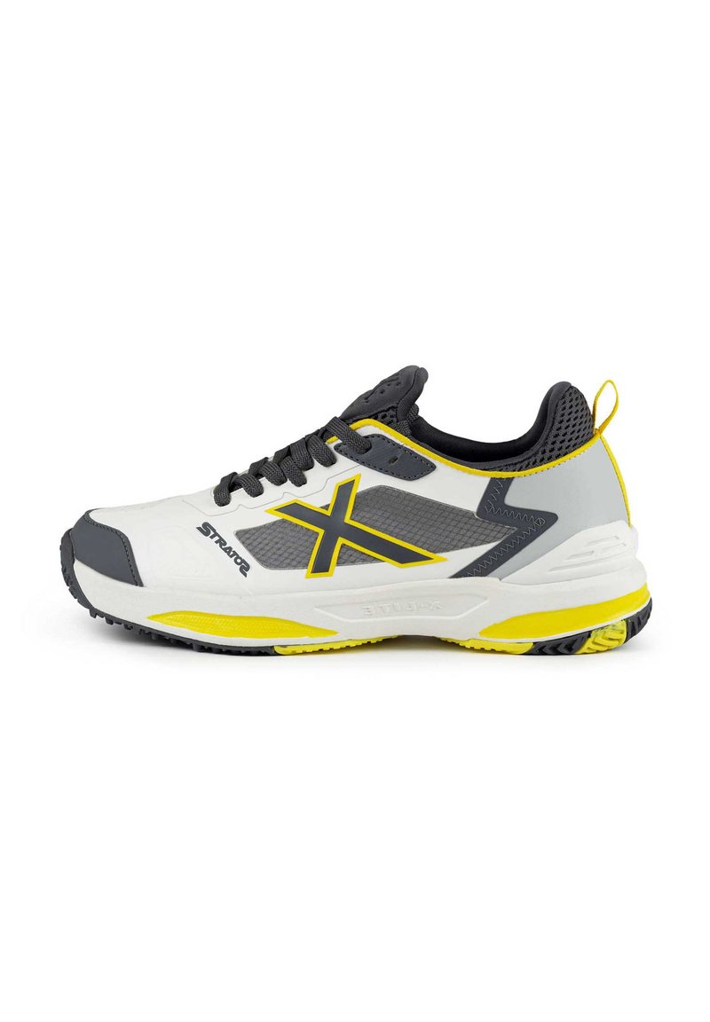 Scarpe sportive con una parte superiore in sintetico bianco, dettagli grigi e gialli, inserti in rete e una suola texturizzata per una migliore aderenza.