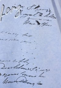 Světle modré bavlněné tričko s černým ručně psaným textem a třpytivými kamínky rozptýlenými na přední straně.