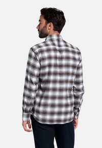 Geruite shirt in bruin, blauw en wit. Lange mouwen met knoopmanchetten. Voorzien van een kraag en een gebogen zoom. Katoenen stof, casual pasvorm.