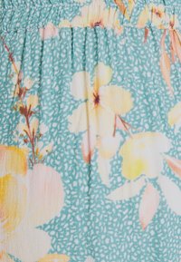 Floral fabric with a turquoise background. Features large yellow and pink flowers, with subtle green foliage and a textured finish.
